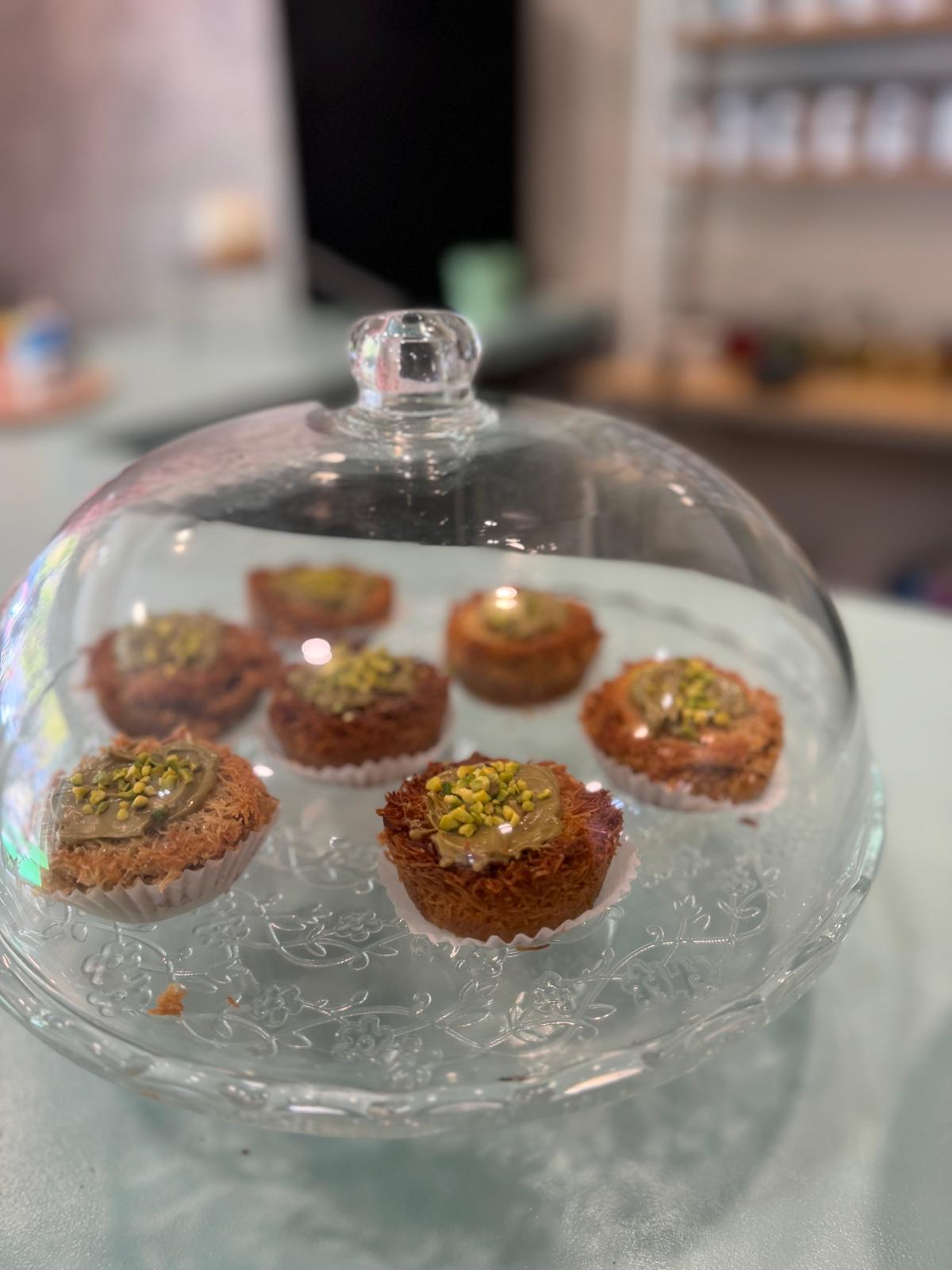 Dulces árabes de kunafa con crema de pistacho bajo campana de cristal en Mediterránea Café, Zaragoza