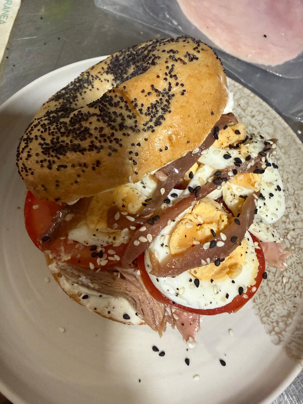 Bagel de anchoas, huevo cocido y tomate natural servido en Mediterránea Café, Zaragoza