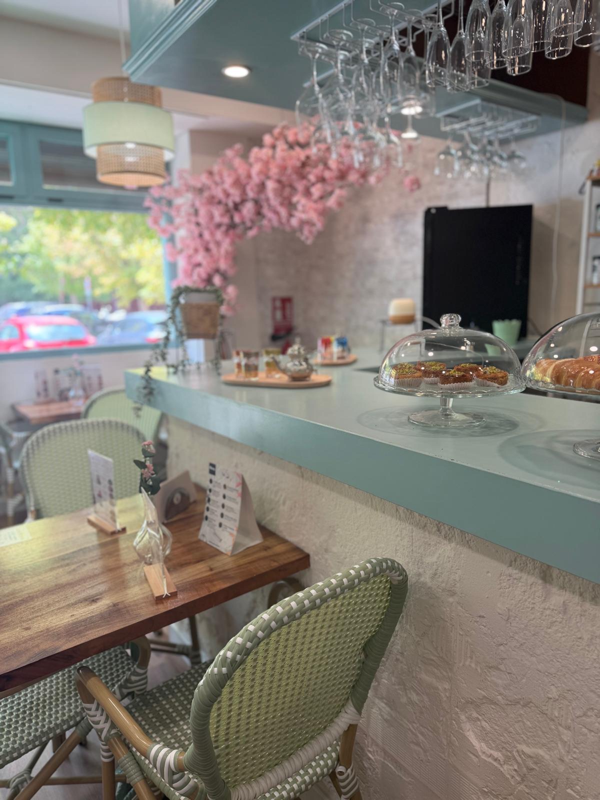 Barra de Mediterránea Café con campana de cristal, dulces de pistacho y copas colgadas en Zaragoza